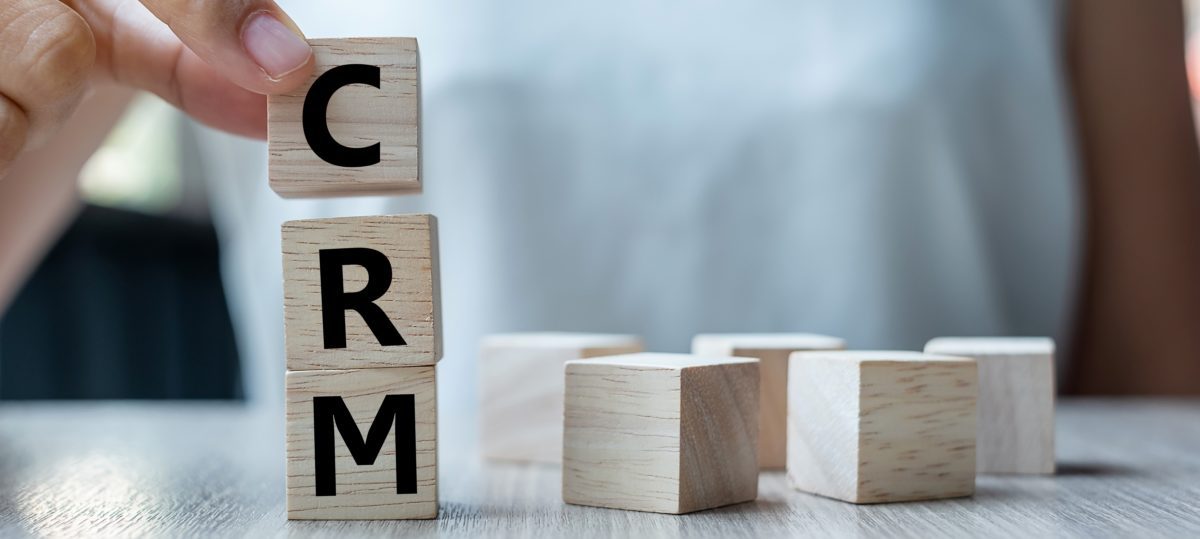 Business woman hand holding wooden cube with crm